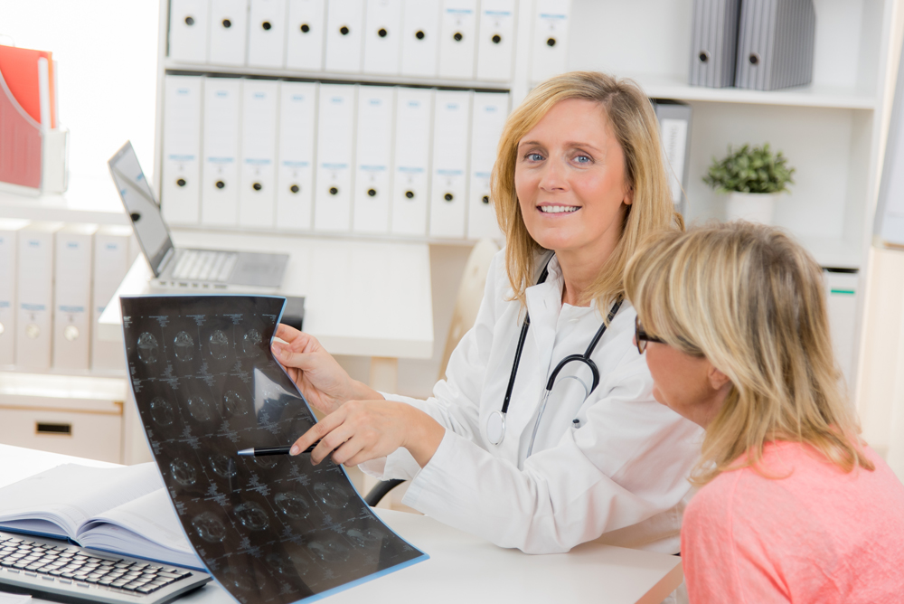 freundliche ärztin zeigt auf ein mrt bild